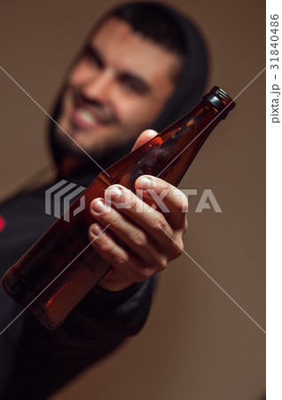 Young smiling man holding beer bottle in hands 31840486
