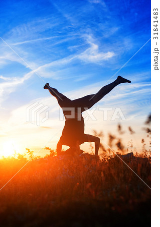 Young man practicing yoga and stretching on a rock Young man practicing yoga and stretching on a rock 31841483