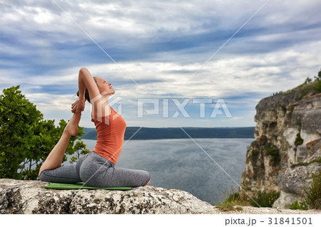 Young woman doing yoga exercise pigeon asana on Young woman doing yoga exercise pigeon asana on 31841501