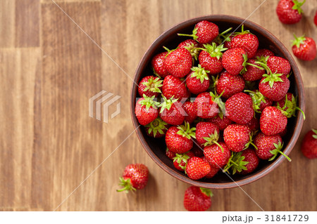 Fresh red strawberries in a brown clay bowl on 31841729