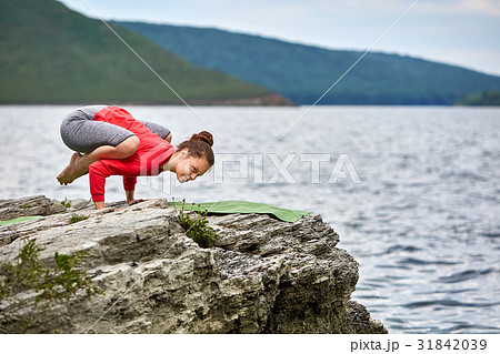 Young woman doing yoga pose arm balance on the Young woman doing yoga pose arm balance on the 31842039