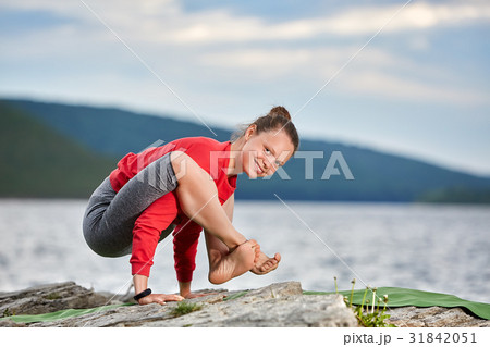 Young woman doing yoga pose arm balance on the 31842051