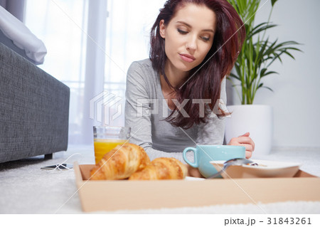 Portrait of happy woman eating breakfast in bedroom, smiling an Portrait of happy woman eating breakfast in bedroom, smiling an 31843261