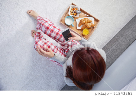 Portrait of happy woman eating breakfast in bedroom, smiling an Portrait of happy woman eating breakfast in bedroom, smiling an 31843265