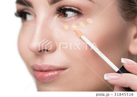 Jolly youthful woman using visage make-up 31845516