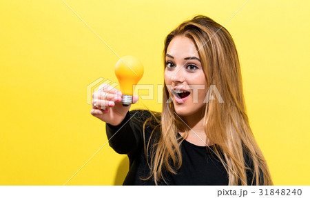 Young woman holding a light bulb 31848240