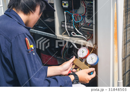 Technician is checking air conditioner 31848503