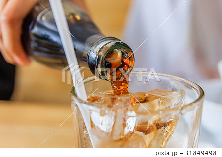 Close up of Pouring cola in a glass from a bottle 31849498