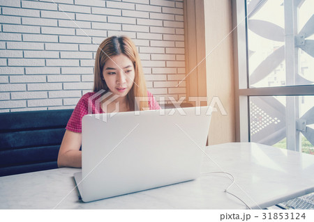 Asian girl working at a coffee shop with a laptop 31853124