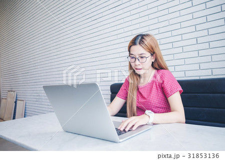 Asian girl working at a coffee shop sitting 31853136