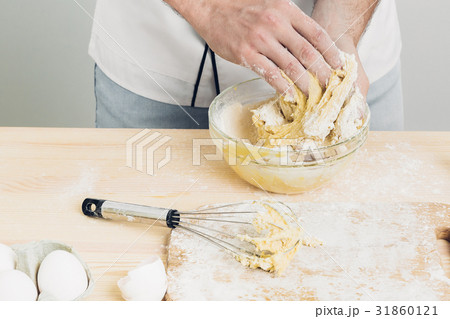 Chef man in uniform kneading raw dough in kitchen 31860121