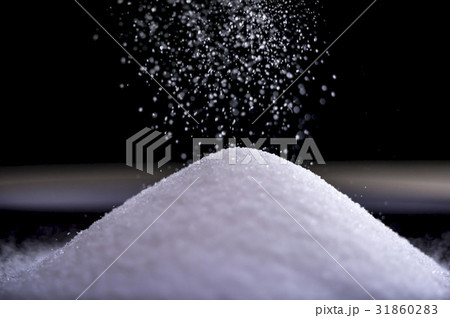 Flowing sugar forming a pile as it falls 31860283
