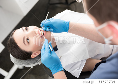 Odontologist examining teeth of happy woman 31873734