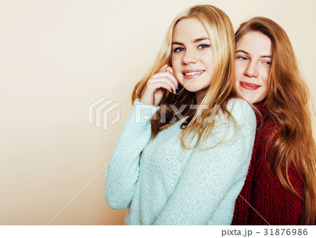 Two young girlfriends in winter sweaters indoors 31876986