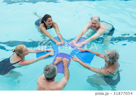 Senior swimmers with trainer enjoying in swimming pool Senior swimmers with trainer enjoying in swimming pool 31877054