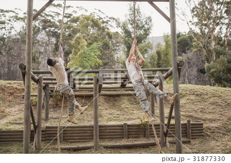 Military soldiers climbing rope during obstacle course training 31877330
