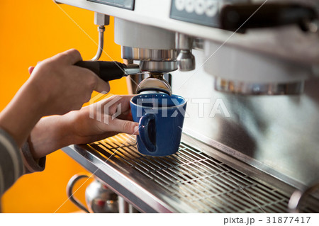 Female barista preparing coffee with machine in cafeteria 31877417
