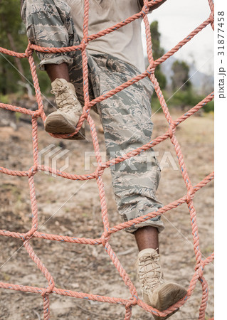 Military soldier climbing a net during obstacle course 31877458