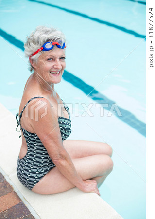 Portrait of senior woman sitting on poolside 31877524