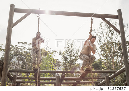 Military soldiers climbing rope during obstacle course training 31877627