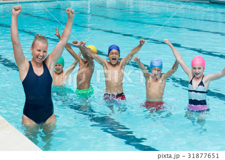 Female instructor with children enjoying in swimming pool Female instructor with children enjoying in swimming pool 31877651