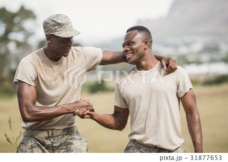 Military soldiers shaking hands during obstacle course Military soldiers shaking hands during obstacle course 31877653