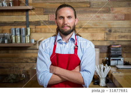 Male barista standing arms crossed in cafeteria 31877681