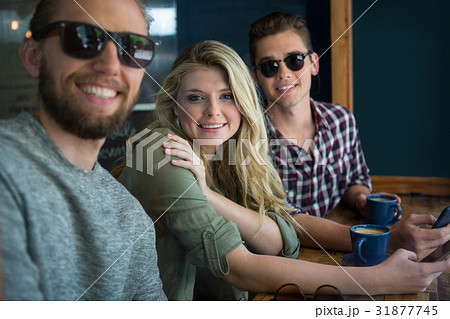 Happy male and female friends at table in cafe Happy male and female friends at table in cafe 31877745
