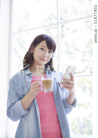 スマートフォンとカップを持つ女性 スマートフォンとカップを持つ女性 31877802
