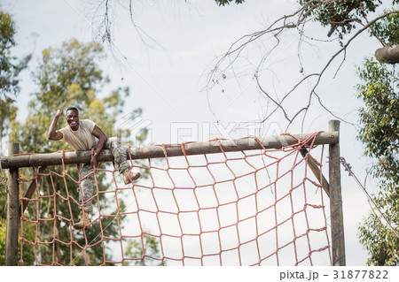 Military soldier climbing net during obstacle course Military soldier climbing net during obstacle course 31877822