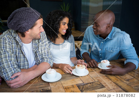Friends talking while having coffee at table in coffee shop 31878082