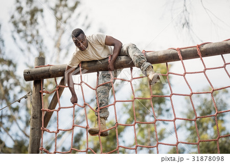 Military soldier climbing net during obstacle course Military soldier climbing net during obstacle course 31878098