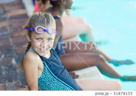 Happy girl sitting with friends at poolside 31878155