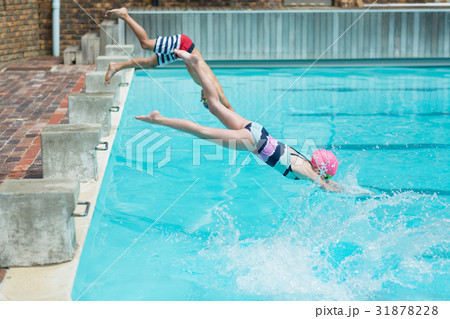 Children diving in water at poolside 31878228