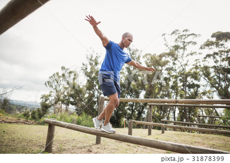 Fit man balancing on hurdles during obstacle course training Fit man balancing on hurdles during obstacle course training 31878399