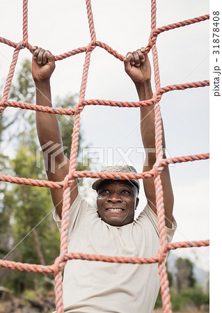 Military soldier climbing a net during obstacle course 31878408