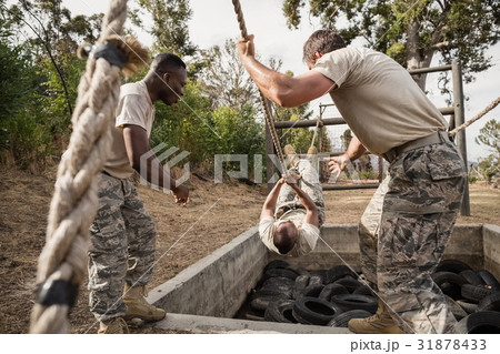 Young military soldiers practicing rope climbing during obstacle course 31878433