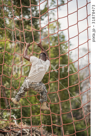 Military soldier climbing net during obstacle course 31878473