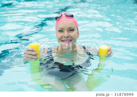 Mature woman swimming with pool noodle Mature woman swimming with pool noodle 31878999