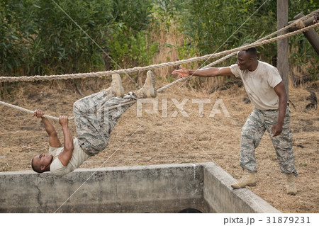 Military soldiers climbing rope during obstacle course training Military soldiers climbing rope during obstacle course training 31879231