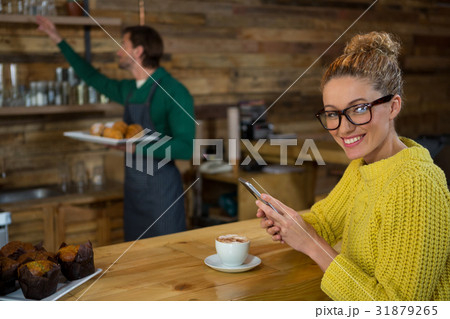 Portrait of happy woman using mobile phone in coffee shop Portrait of happy woman using mobile phone in coffee shop 31879265