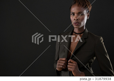 Androgynous man in suit posing against grey background Androgynous man in suit posing against grey background 31879938