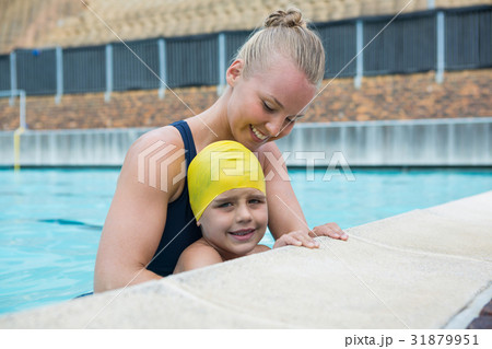 Female instructor and young boy relaxing at poolside 31879951