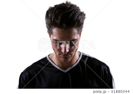 Upset football player looking down Upset football player looking down 31880344