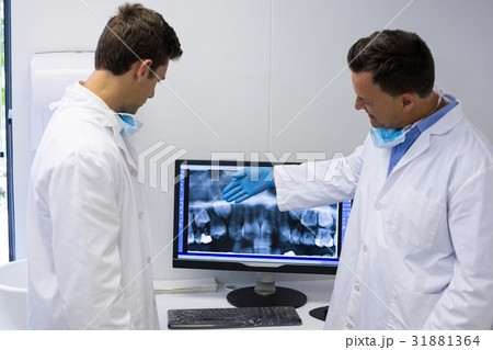 Dentist examining x-ray report on computer Dentist examining x-ray report on computer 31881364
