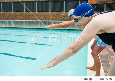 Senior couple ready to jump in swimming pool Senior couple ready to jump in swimming pool 31881576
