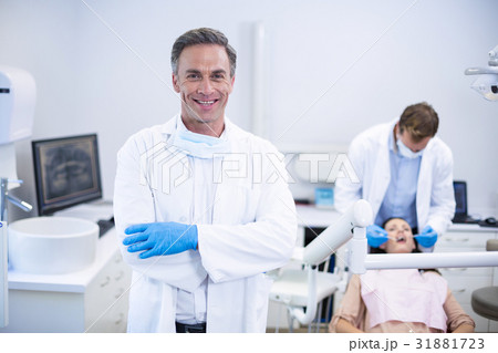 Smiling dentist standing with arms crossed 31881723