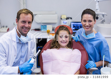 Portrait of smiling dentists and young patient 31881999