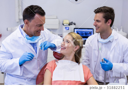Dentists interacting with female patient 31882251