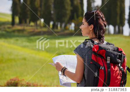 Woman holding map with backpack in the road and Tuscany backgro Woman holding map with backpack in the road and Tuscany backgro 31887363
